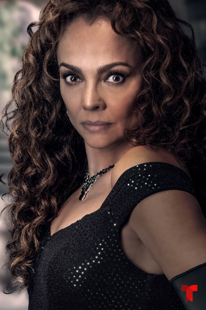 Retrato de una mujer con cabello rizado y una expresión seria, vistiendo un vestido negro y joyas brillantes.